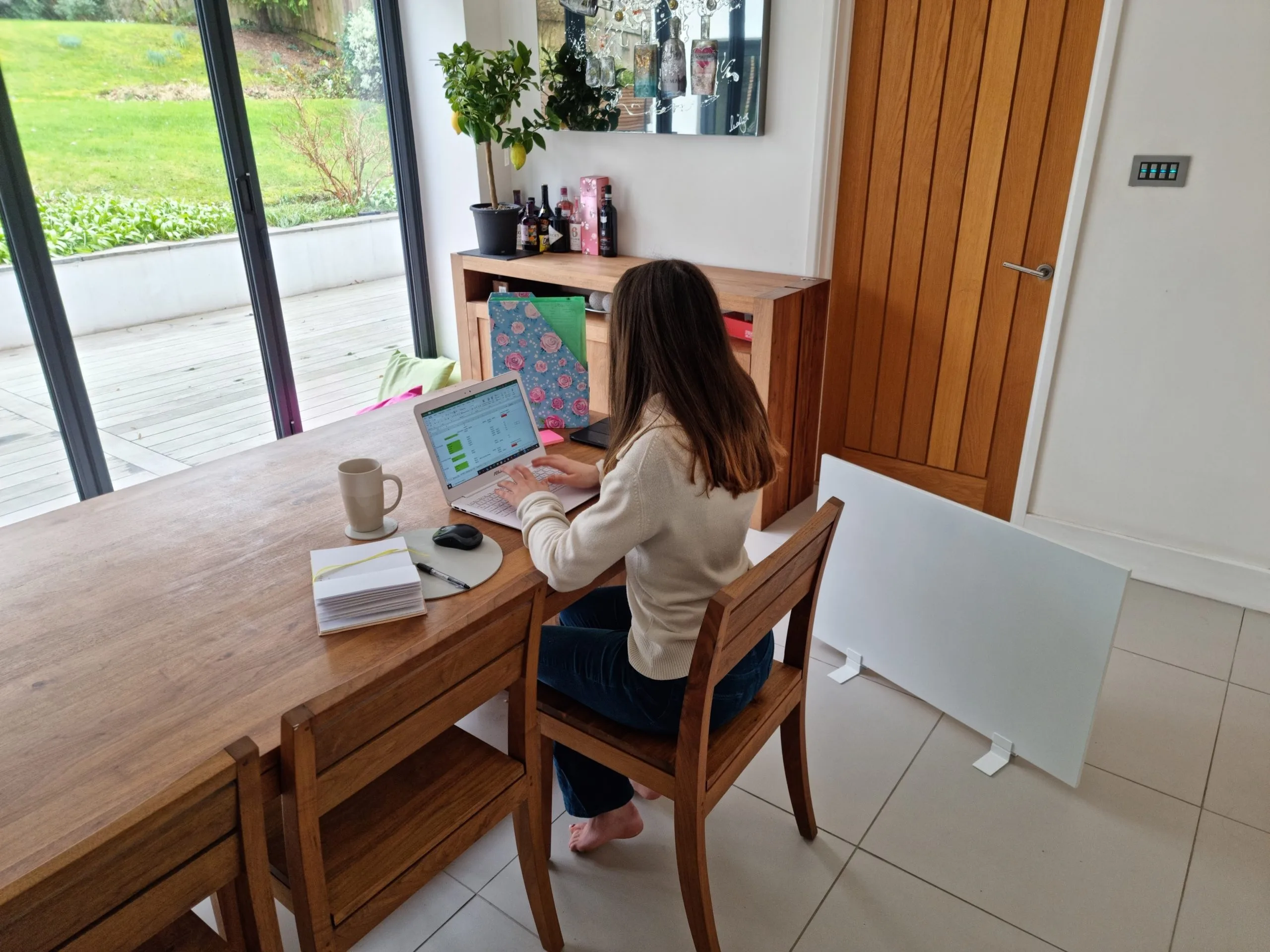 Vrouw die thuis werkt en geniet van de draagbare Herschel Select-verwarming