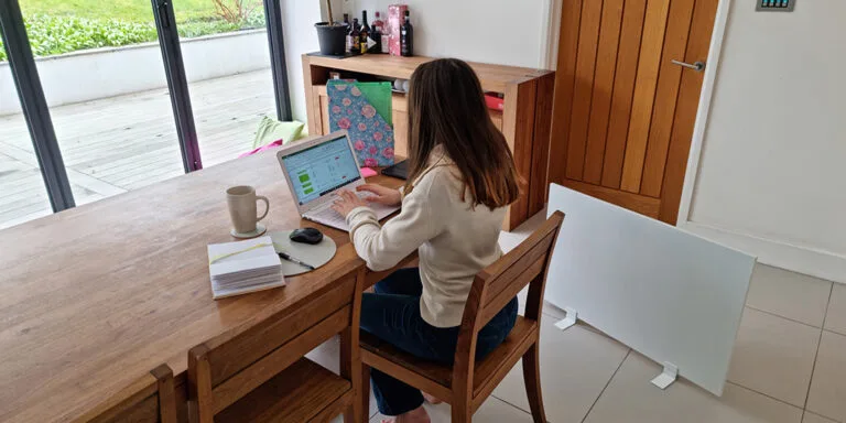 Vrouw die thuis werkt en geniet van de draagbare Herschel Select-verwarming