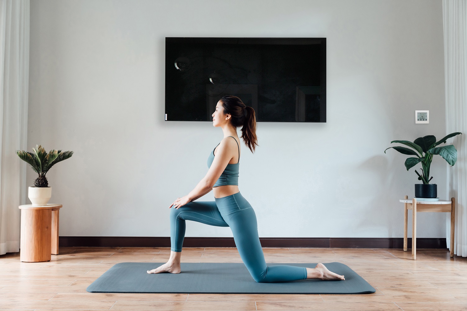 Stijlvolle zwarte glazen paneelverwarming, vrouw doet thuis yoga